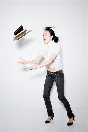 Woman throwing books Stock Photo - Premium Royalty-Free, Code: 614-02935163