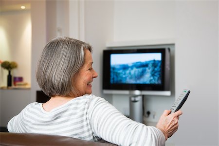 Mature woman watching television Stock Photo - Premium Royalty-Free, Code: 614-02933839