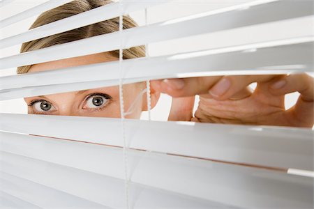 secret - Woman looking through blinds Stock Photo - Premium Royalty-Free, Code: 614-02933970