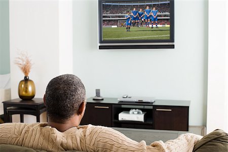 Man watching television Stock Photo - Premium Royalty-Free, Code: 614-02984051