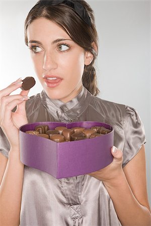 Woman sneakily eating a chocolate Foto de stock - Sin royalties Premium, Código: 614-02984243
