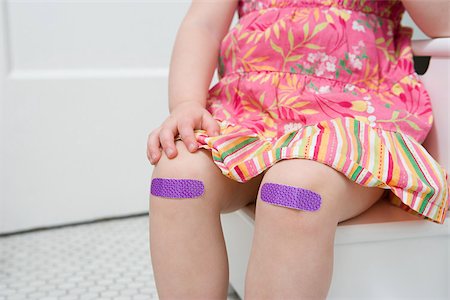 Girl with plasters on her knees Foto de stock - Royalty Free Premium, Número: 614-03020254