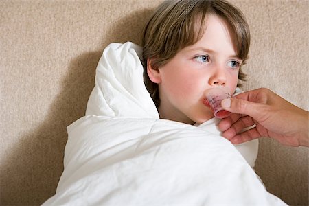 Boy being given medicine Stock Photo - Premium Royalty-Free, Code: 614-03020281