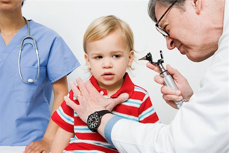 pediatric doctor boy exam - Doctor looking in boys ear Stock Photo - Premium Royalty-Free, Code: 614-03020394