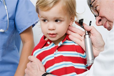 Doctor looking in boys ear Stock Photo - Premium Royalty-Free, Code: 614-03020401