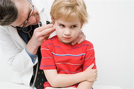 pediatrician examining boy - Doctor looking in boys ear Stock Photo - Premium Royalty-Free, Code: 614-03020430