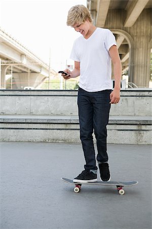 simsearch:695-05768222,k - Teenage boy on skateboard with cellphone Foto de stock - Sin royalties Premium, Código: 614-03080166