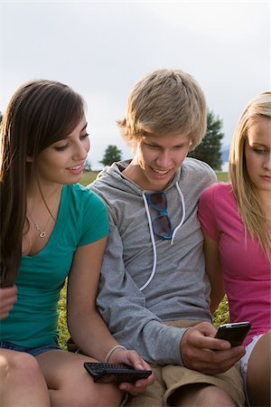Teenage friends with cellphones Stock Photo - Premium Royalty-Free, Code: 614-03080172