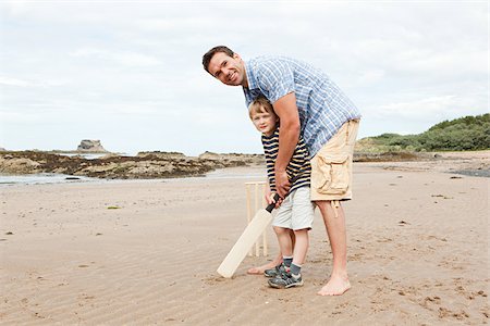 Father and son playing cricket on beach Fotografie stock - Premium Royalty-Free, Codice: 614-03080479