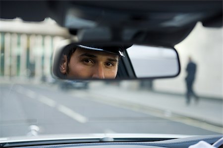 espejo retrovisor - Chauffeur looking in rear view mirror Foto de stock - Sin royalties Premium, Código: 614-03191650