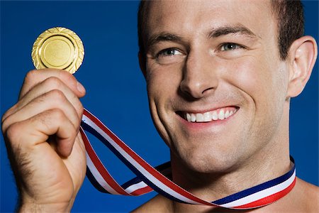 Male athlete holding a medal Stock Photo - Premium Royalty-Free, Code: 614-03228111