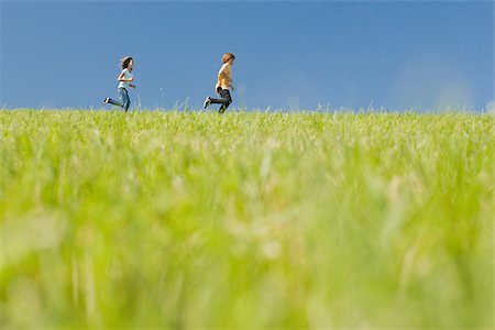 running teenage boy & girl - Boy and girl running in field Stock Photo - Premium Royalty-Free, Code: 614-03228245