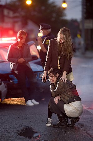 Young people and police officer at scene of car crash Stock Photo - Premium Royalty-Free, Code: 614-03241405