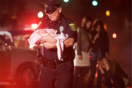 police lights accident - Police officer rescuing a baby Stock Photo - Premium Royalty-Free, Code: 614-03241400