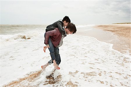 southwold - Man giving girlfriend piggyback in the sea Foto de stock - Sin royalties Premium, Código: 614-03241512