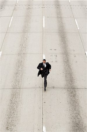 stressful city - Looking down to a businessman running down a road Stock Photo - Premium Royalty-Free, Code: 614-03359588