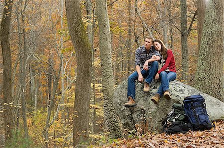 Jeune couple assis sur les rochers dans la forêt Photographie de stock - Premium Libres de Droits, Code: 614-03393329