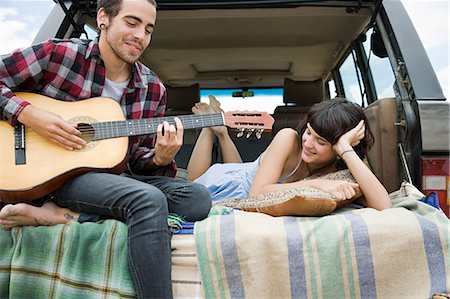 Young man playing guitar to girlfriend Stock Photo - Premium Royalty-Free, Code: 614-03393871