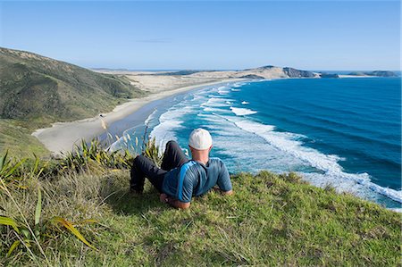 Northland, Cape Reigna, man laying on grass, looking towards beach Foto de stock - Sin royalties Premium, Código: 614-03454982