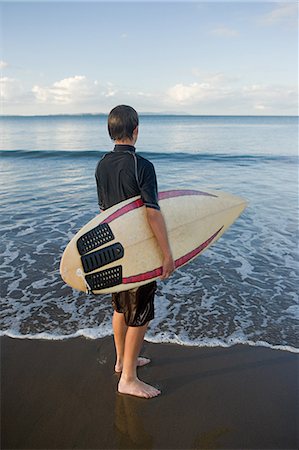 Auckland, young man with surf board on Muriwai Beach Foto de stock - Royalty Free Premium, Número: 614-03455039