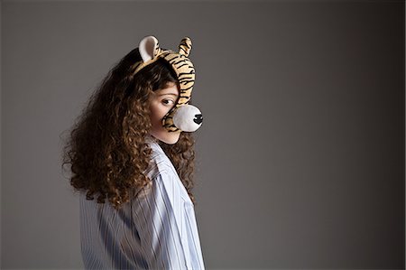 Young girl wearing tiger mask Stock Photo - Premium Royalty-Free, Code: 614-03469566