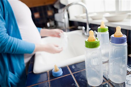 Pregnant woman washing baby bottles Foto de stock - Royalty Free Premium, Número: 614-03506451