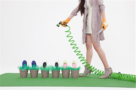 Woman with hosepipe and shoes in flower pots Foto de stock - Sin royalties Premium, Código: 614-03506672