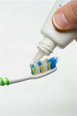 Putting toothpaste on toothbrush Stock Photo - Premium Royalty-Free, Code: 614-03506922