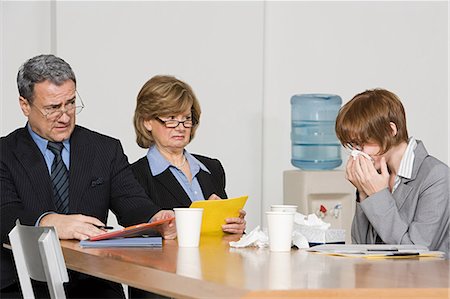 runny nose - Businesswoman blowing nose in office Stock Photo - Premium Royalty-Free, Code: 614-03507002