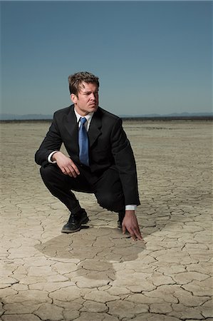 simsearch:614-03507056,k - Businessman crouching in desert landscape Stock Photo - Premium Royalty-Free, Code: 614-03507049