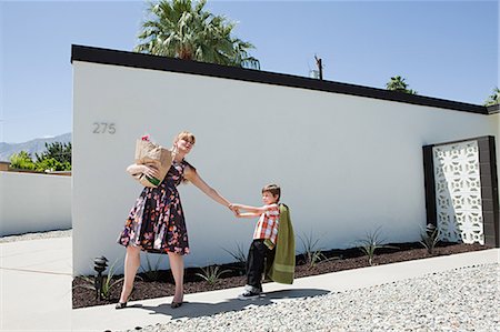 family of superheroes - Mother holding shopping bag and pulling son's arm Stock Photo - Premium Royalty-Free, Code: 614-03507206