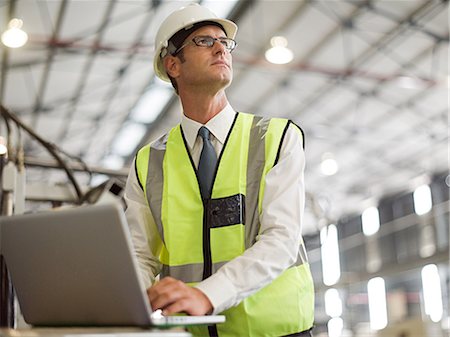 factory worker photography - Mature man using laptop in factory Stock Photo - Premium Royalty-Free, Code: 614-03507374