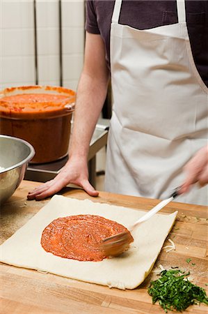 pizza from above on white - Male chef making pizza in commercial kitchen Stock Photo - Premium Royalty-Free, Code: 614-03551581