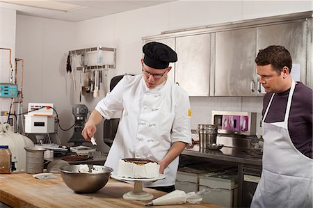 decorating cakes - Chefs preparing food in commercial kitchen Stock Photo - Premium Royalty-Free, Code: 614-03551582