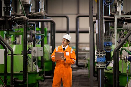 Engineer inspecting machinery in factory Stock Photo - Premium Royalty-Free, Code: 614-03552246