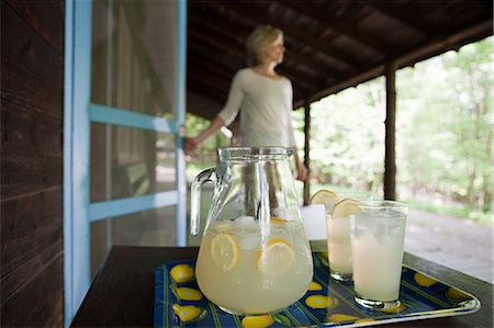Tray of lemonade, woman in background Stock Photo - Premium Royalty-Free, Code: 614-03576500