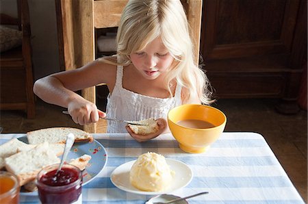 spreading butter on bread - Girls spreading butter on bread Stock Photo - Premium Royalty-Free, Code: 614-03576636