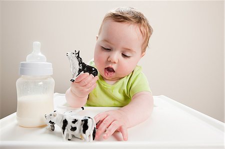 Baby boy with bottle of milk and toy cow Foto de stock - Royalty Free Premium, Número: 614-03576699