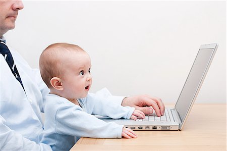 Working father and baby at laptop Stock Photo - Premium Royalty-Free, Code: 614-03577055