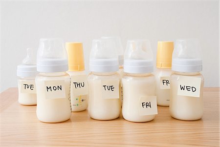 Baby bottles with days of the week on adhesive notes Foto de stock - Royalty Free Premium, Número: 614-03577063