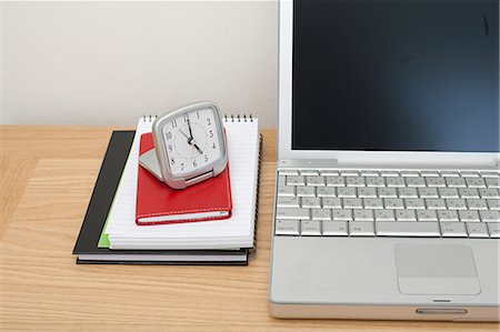 Laptop, notebooks and alarm clock Stock Photo - Premium Royalty-Free, Code: 614-03577083