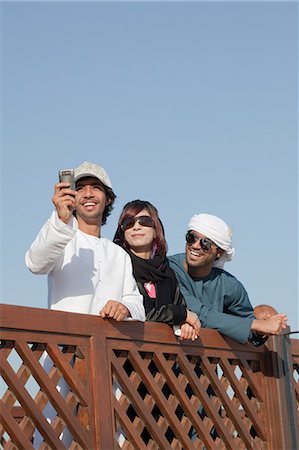 Middle Eastern people by fence, low angle view Stock Photo - Premium Royalty-Free, Code: 614-03577142