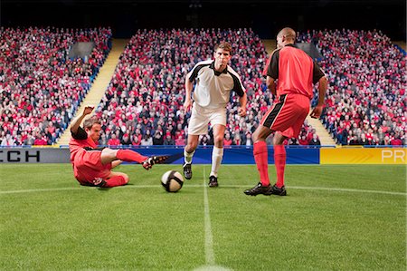 Football players kicking the ball Stock Photo - Premium Royalty-Free, Code: 614-03647718