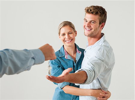 realtor woman - Young couple being handed house keys Stock Photo - Premium Royalty-Free, Code: 614-03648187