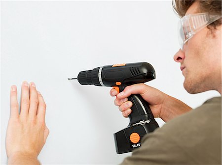 drilling - Young man using electric drill Stock Photo - Premium Royalty-Free, Code: 614-03648197