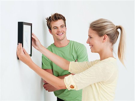 framed photograph - Young couple hanging a picture Stock Photo - Premium Royalty-Free, Code: 614-03648191