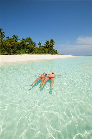 paradise beach - Couple floating in the sea, Baughagello Island, South Huvadhu Atoll, Maldives Foto de stock - Sin royalties Premium, Código: 614-03648491