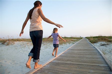 Mother and daughter walking on beach walkway Stock Photo - Premium Royalty-Free, Code: 614-03648750