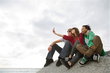 Friends taking photograph of themselves Stock Photo - Premium Royalty-Free, Code: 614-03648954