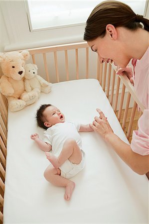 parent crib baby - Mère avec le bébé dans le lit d'enfant Photographie de stock - Premium Libres de Droits, Code: 614-03684081